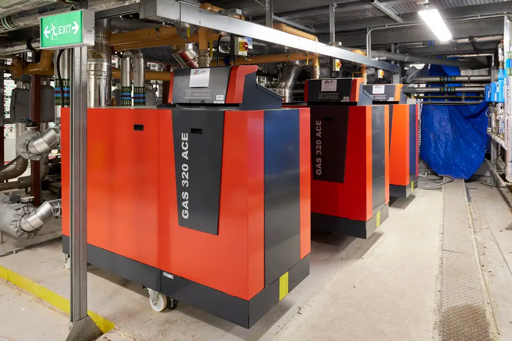 3 red boilers in a services room