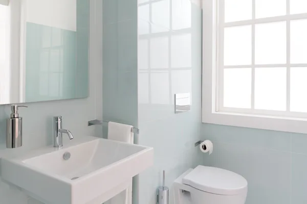 A white and blue bathroom complete with sink and toilet